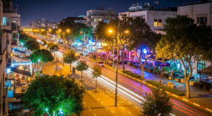 איור של צעירים רוקדים במועדון תל אביבי תוסס, אורות ניאון וסמארטפון עם לוגו טלגרם.